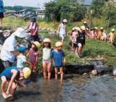 写真：水辺で遊ぶ大勢の子どもたち