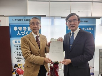 委員長が教育長へ報告している様子