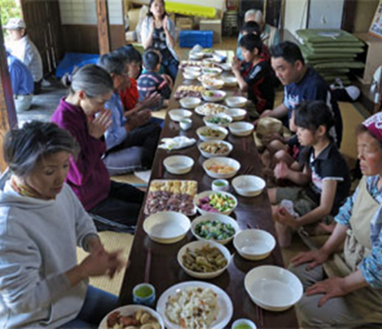 収穫した野菜を使ってみんなでご飯を食べている様子