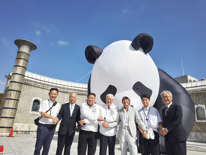 大きなパンダの前で関係者の集合写真