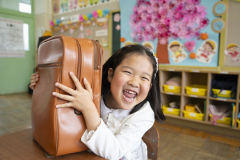新しいランドセルを手に笑顔を見せる新一年生